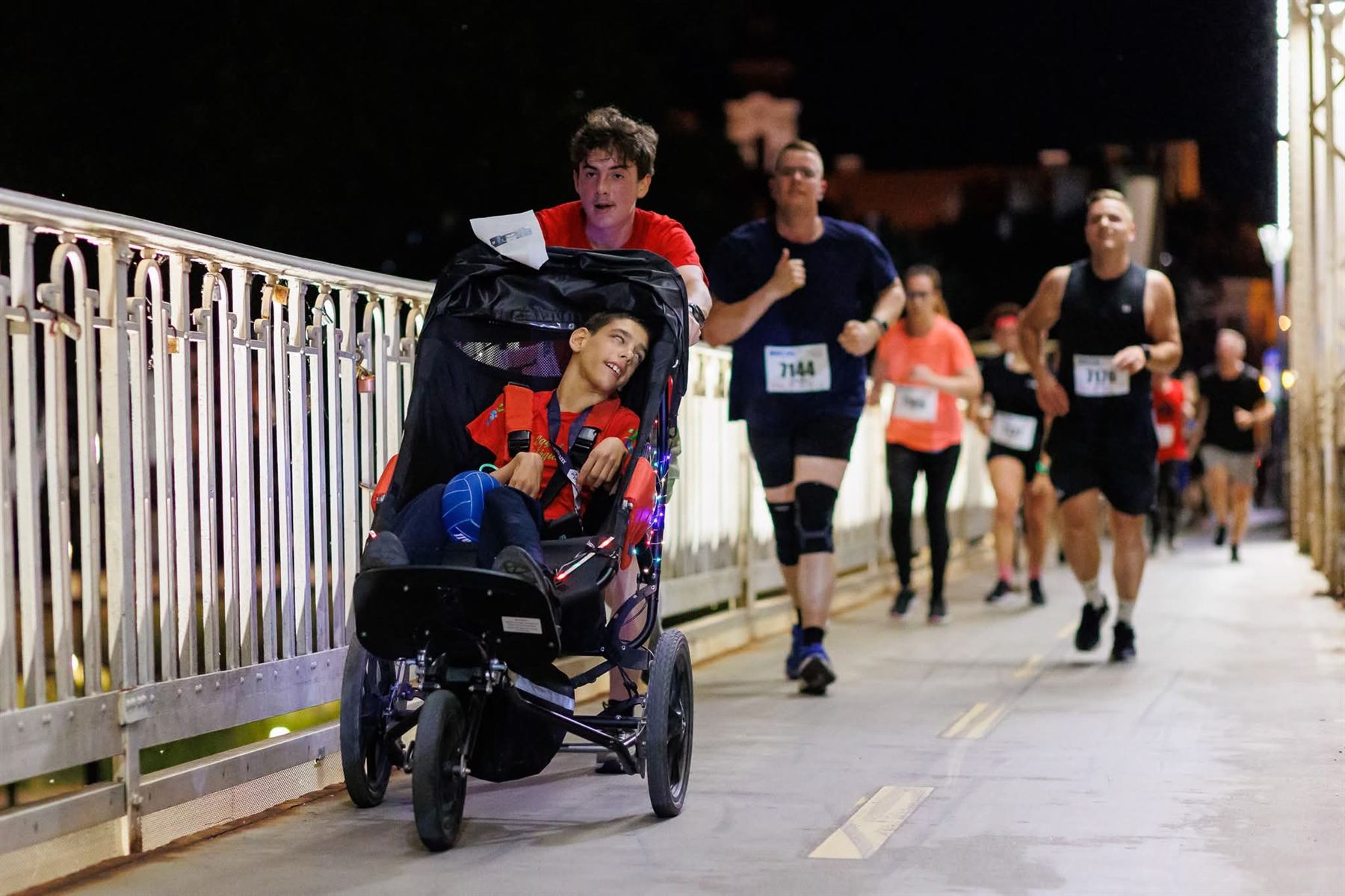 A pair with a running chair on the illuminated Győr route